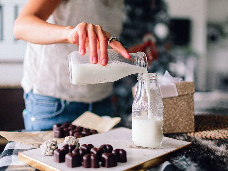 a boy adding milk from one jar to other jar